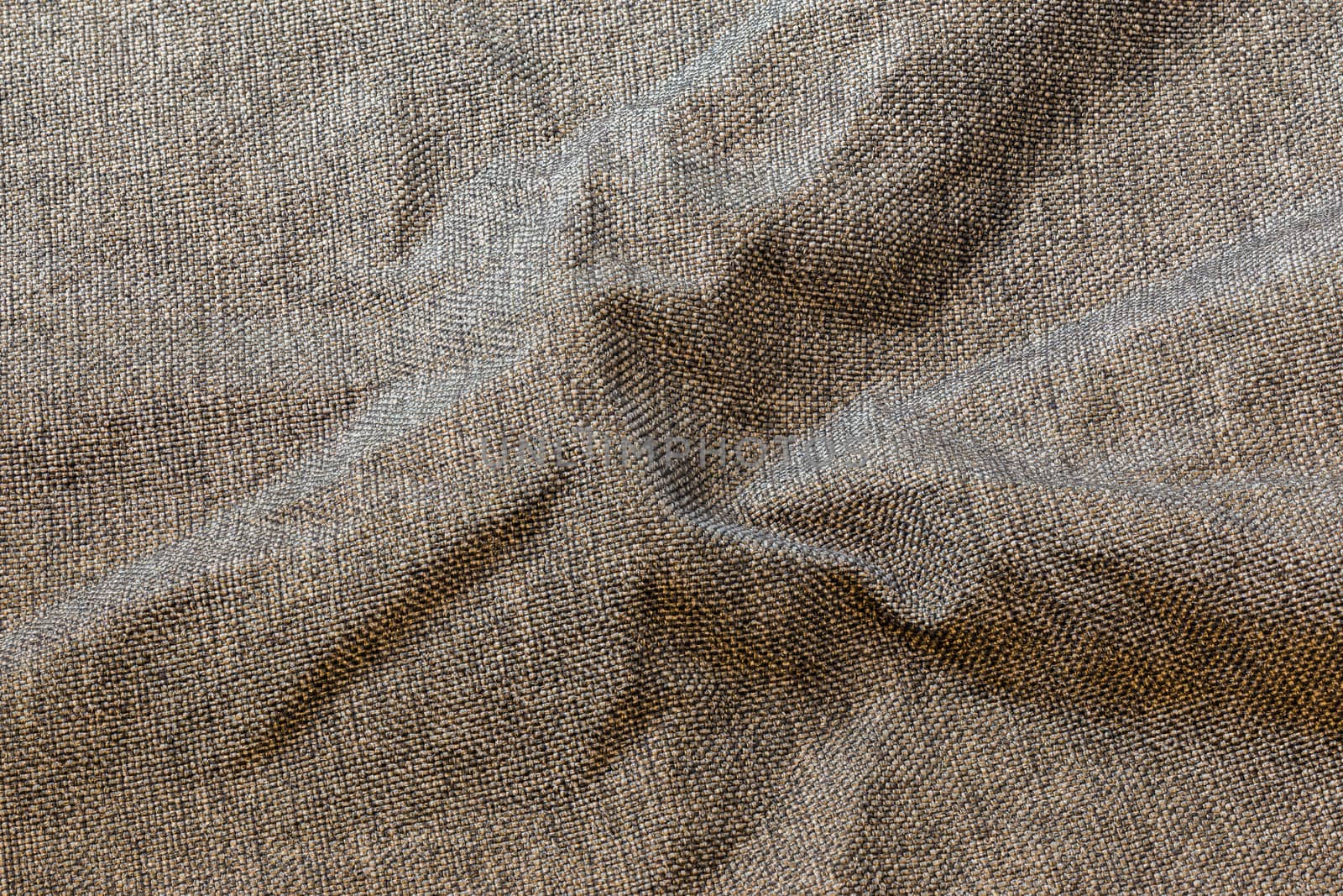 Brown crumpled dense rough fabric background, close up withoun any blurring