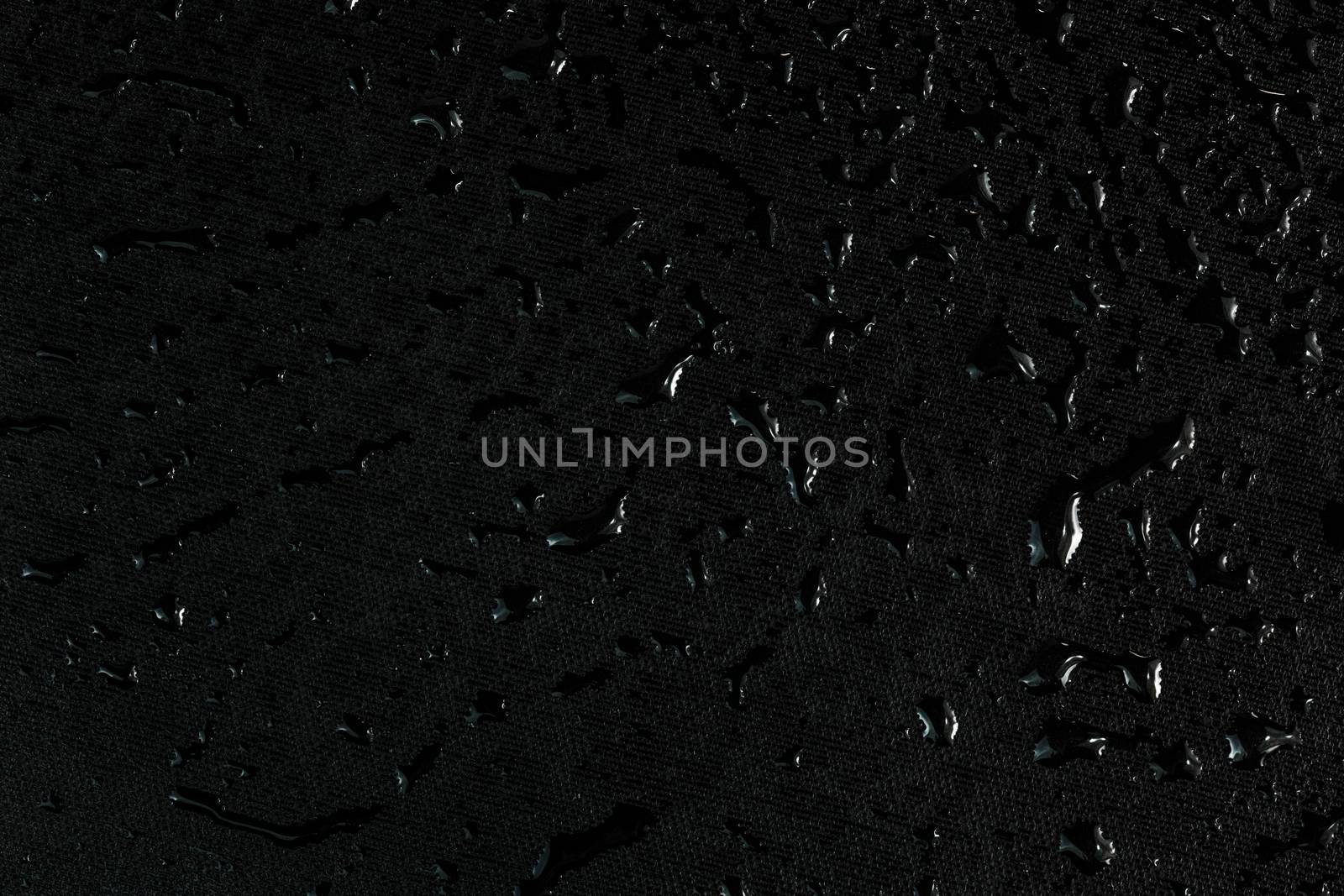 black flat rubber surface with water drops macro background.