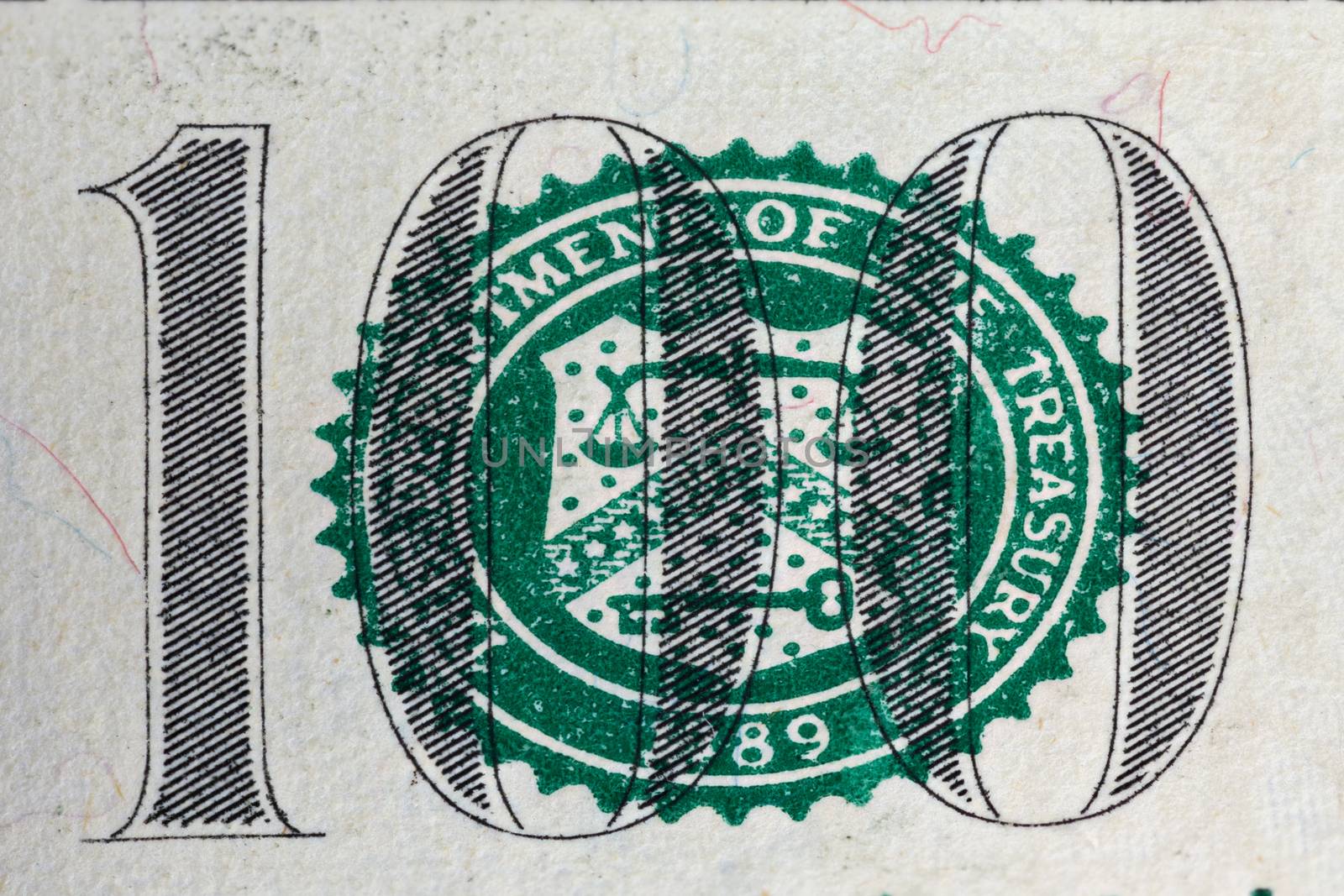 A number of one hundred on dollar bill and United States Treasury Department symbol in macro magnification.