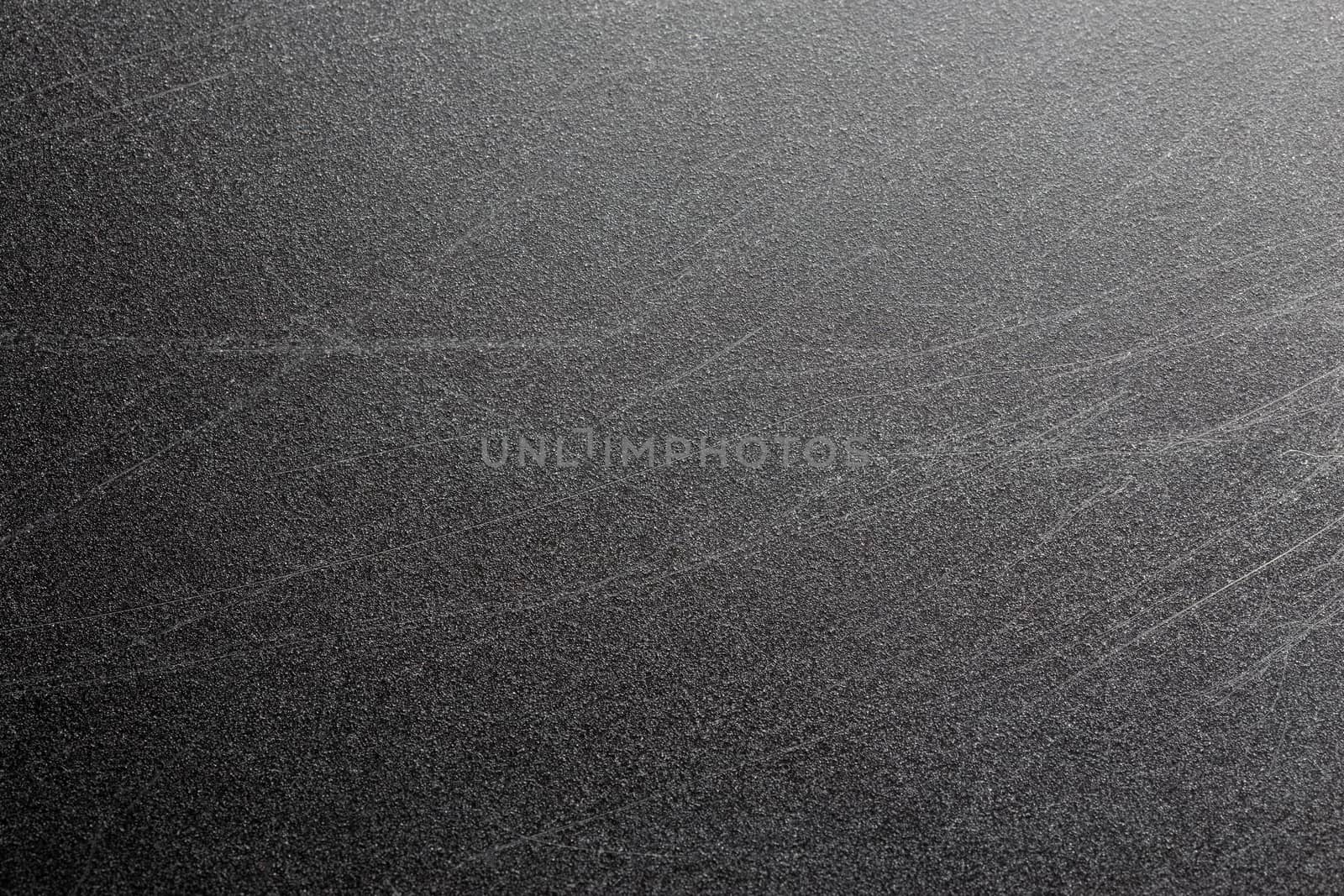 Abstract black scratched suface closeup background with selective focus