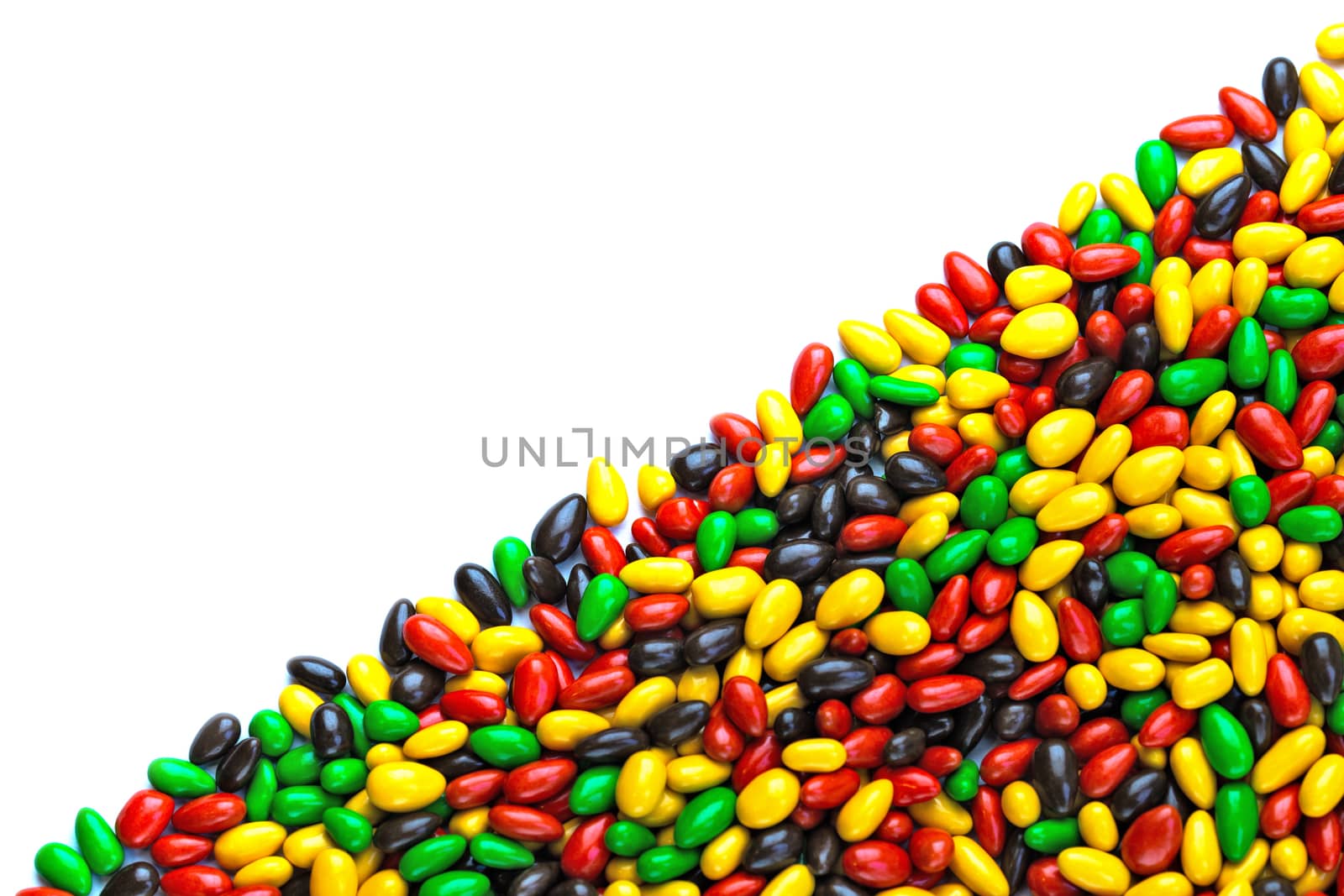 hundreds of small gloss glazed sunflower seeds multicolor flat background with selective focus with isolated side on white backgroud