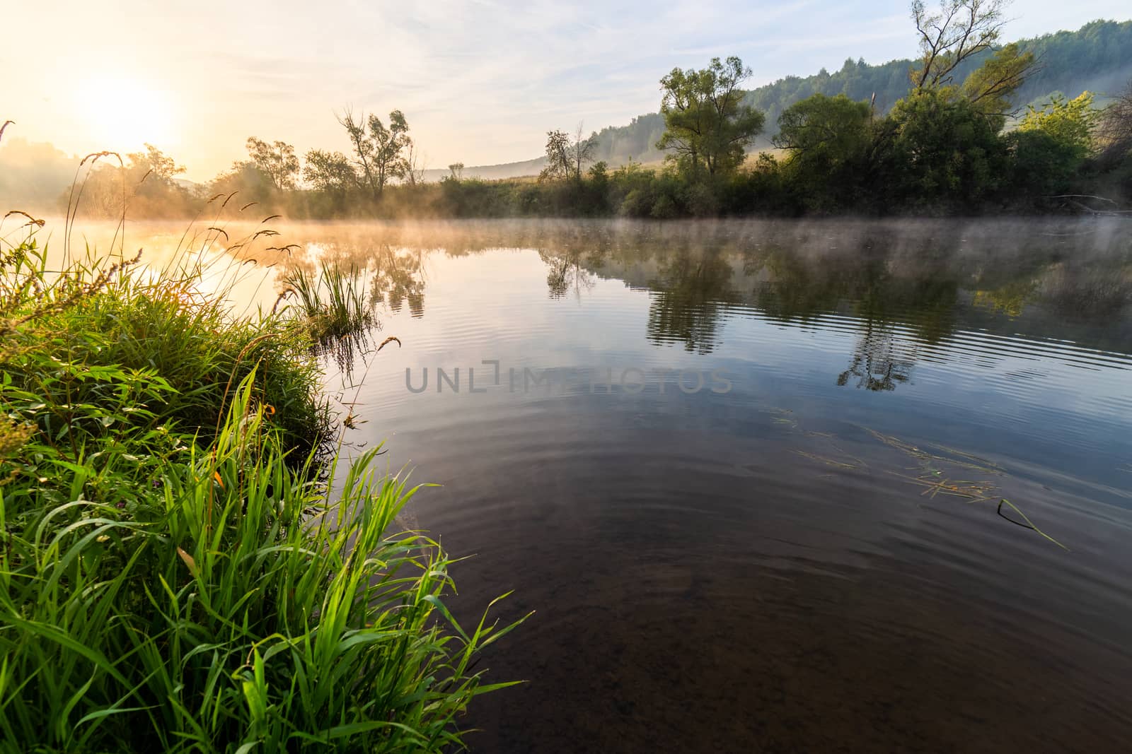 wide angle photo of floating fog on early morning river