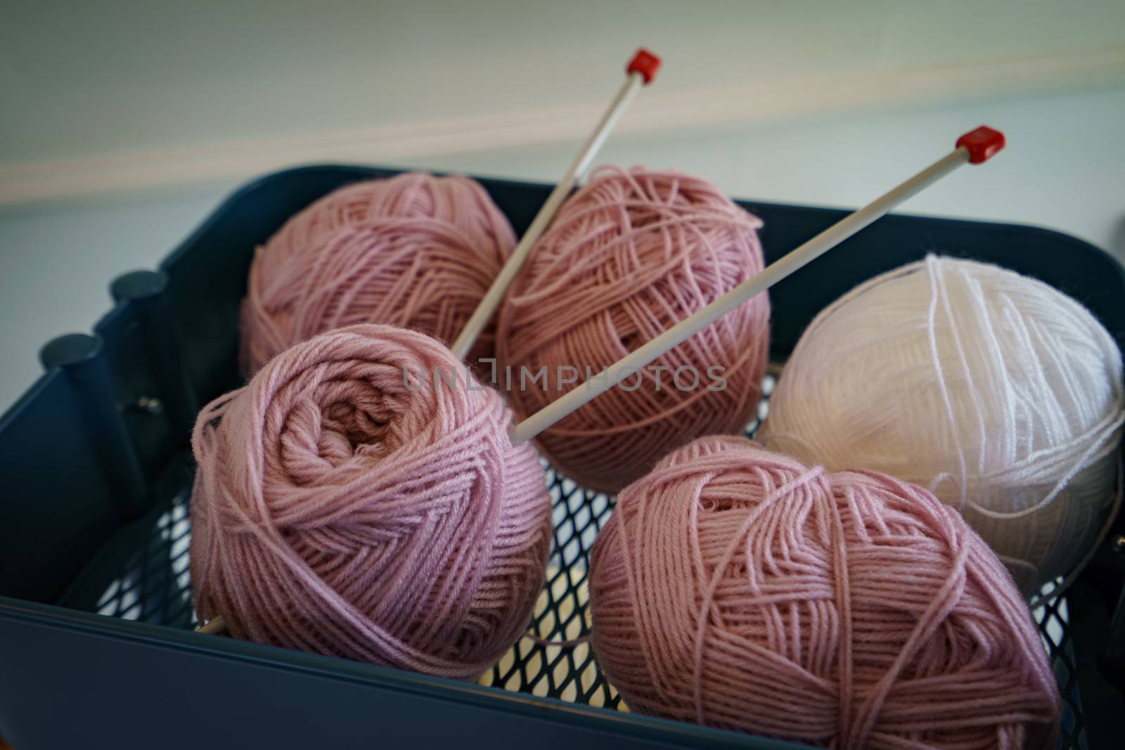 Pink knitting wool and knitting needles. by sirawit99