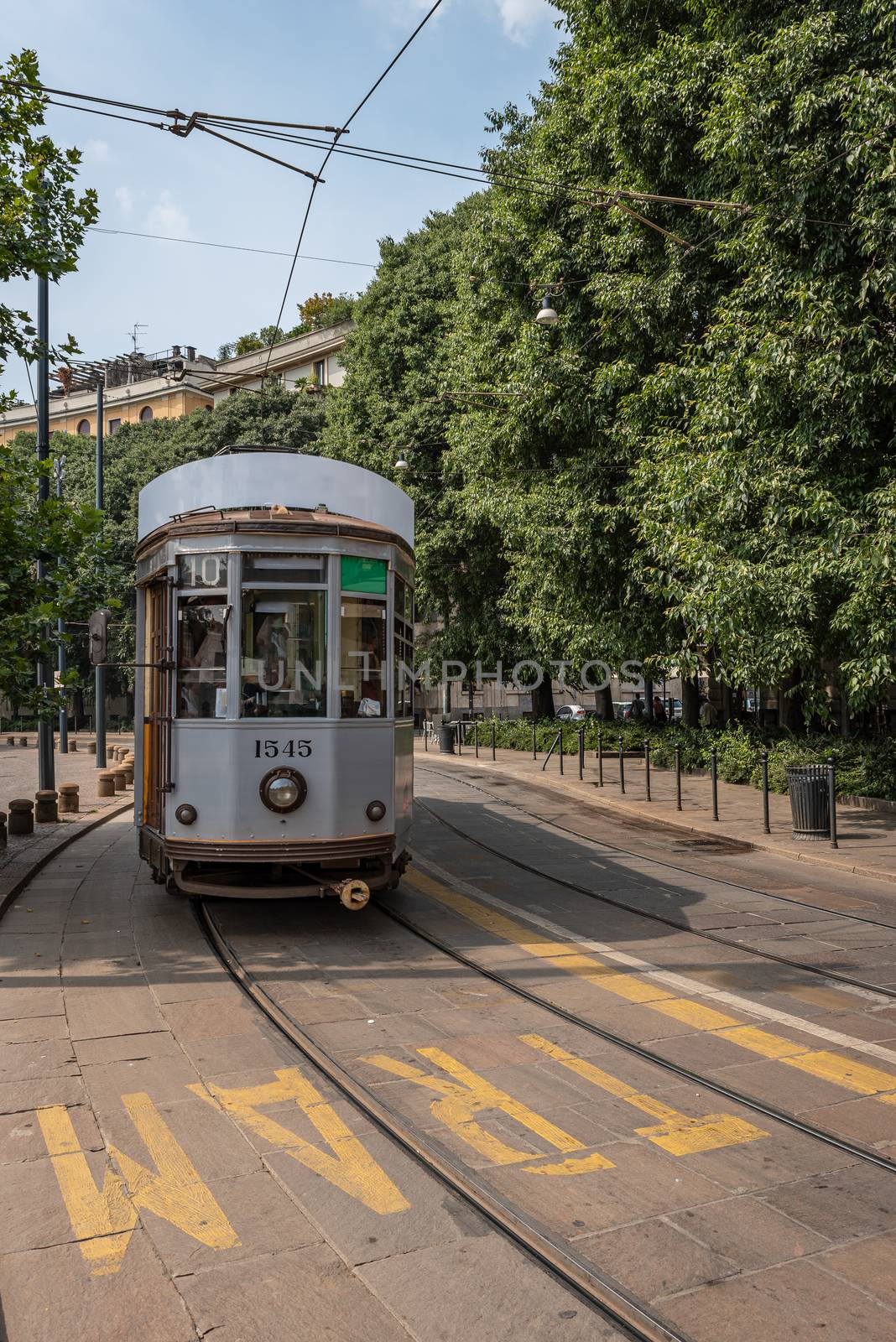 A tram travels in one of the streets of an Italian city, street photography in Milan