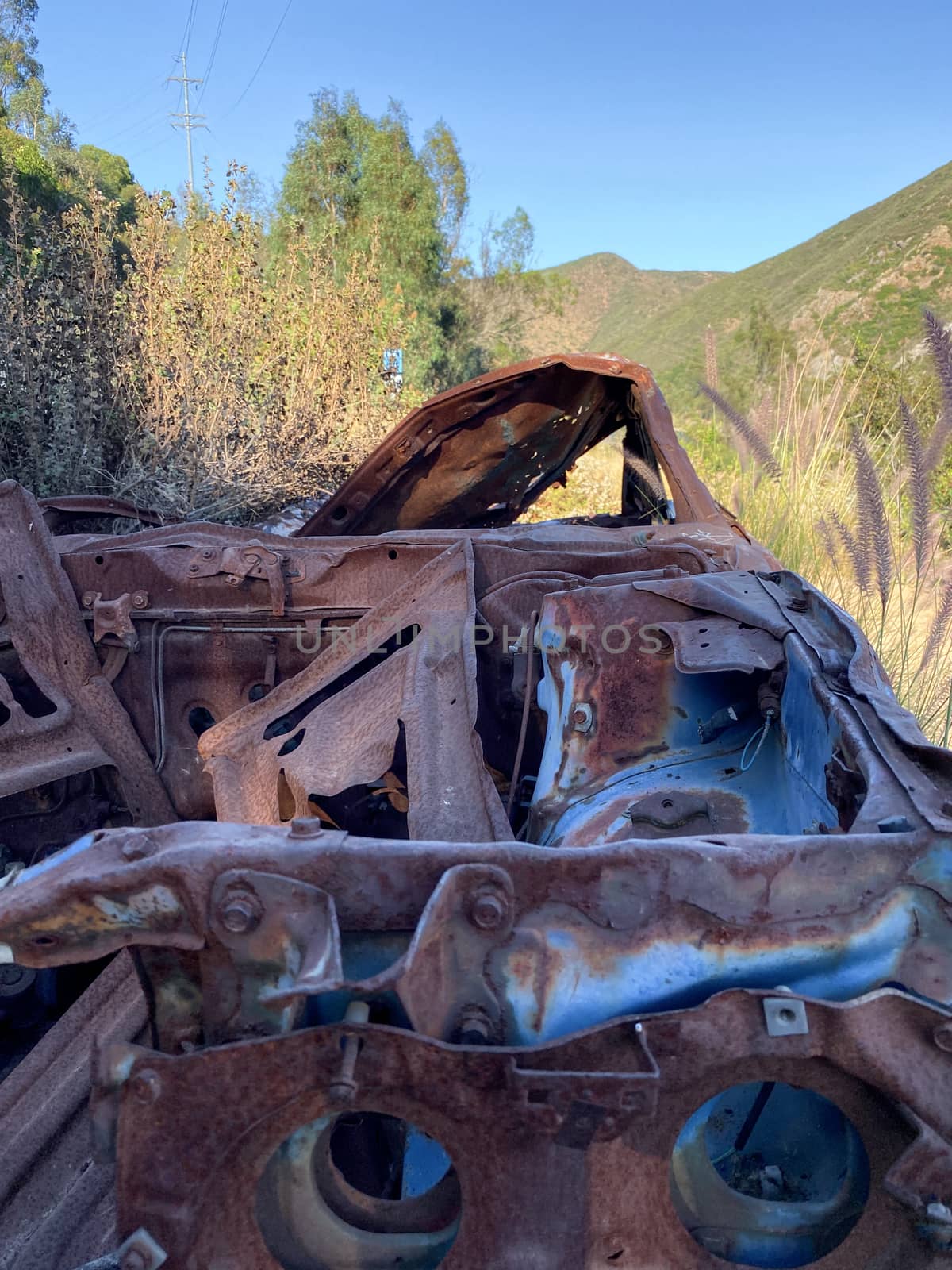Rustic abandoned car in the mountain against blue sky by Bonandbon