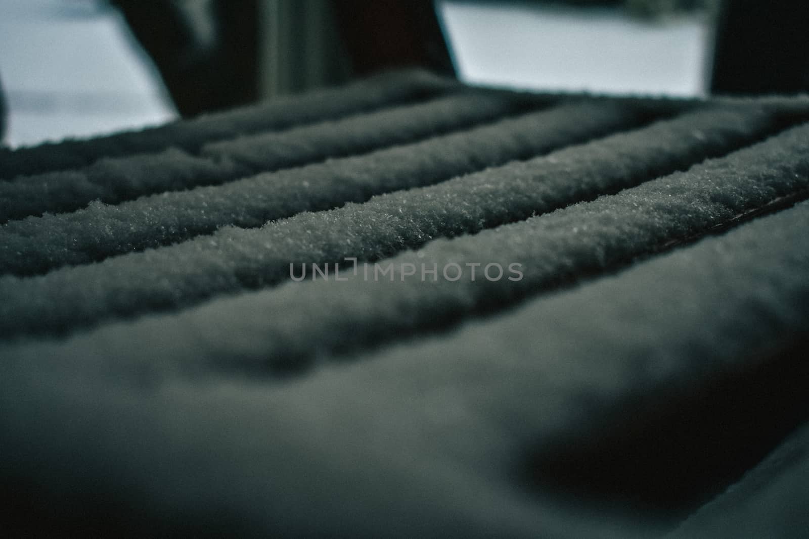 A Close-Up Shot of a Wooden Seat Covered in a Fresh Layer of Snow