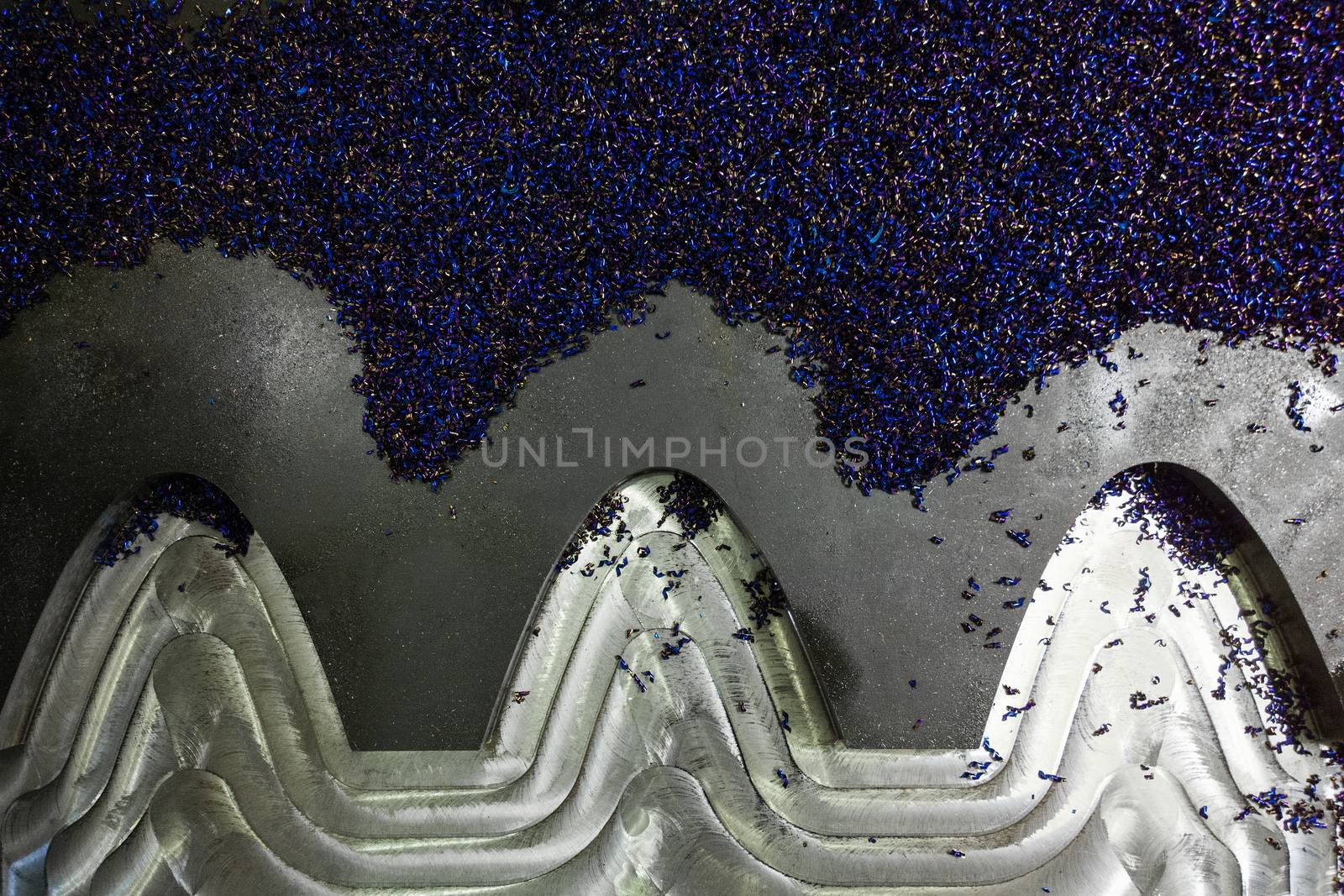 flat semifinished cnc milled plate with curves and layer of small blue discoloration chips
