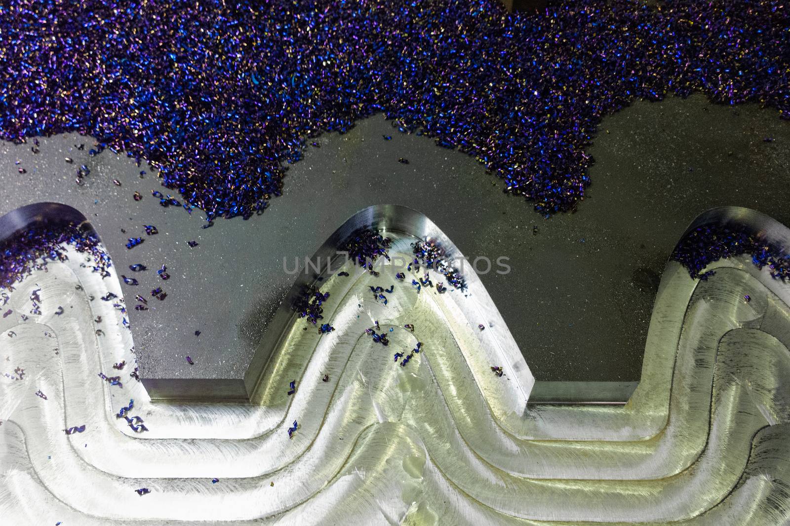 flat semifinished cnc milled plate with curves and layer of small blue discoloration chips