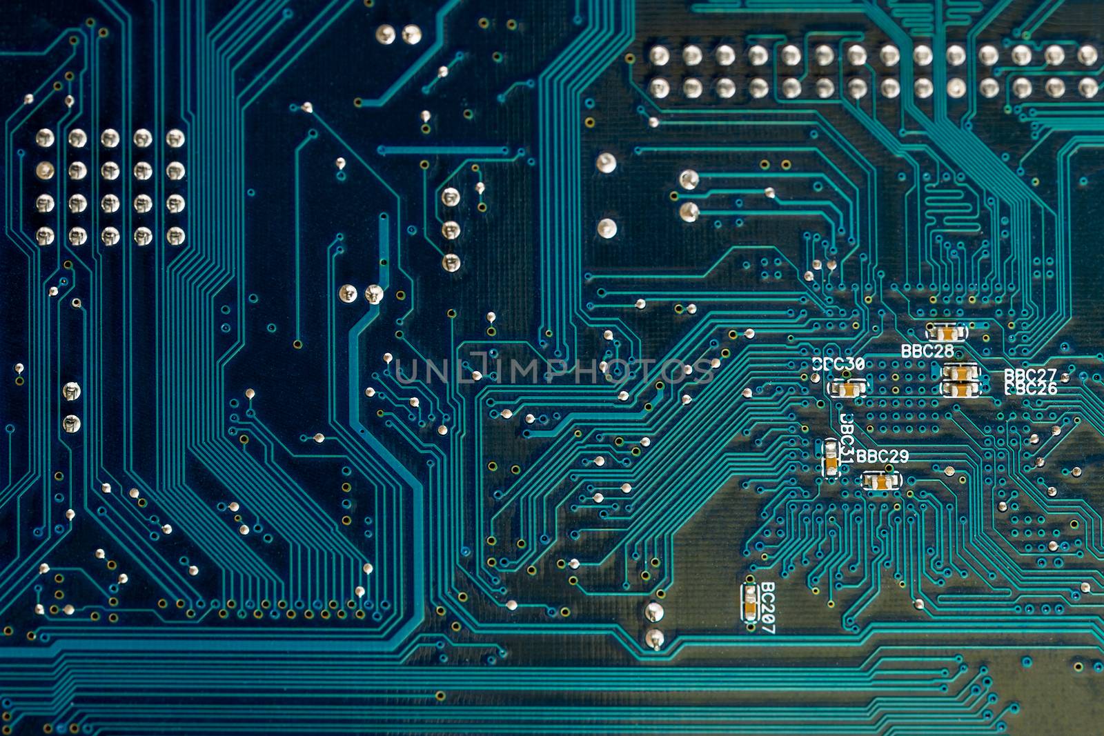 back side of blue pcb board circuit close up technology background with selective focus and some dust on it