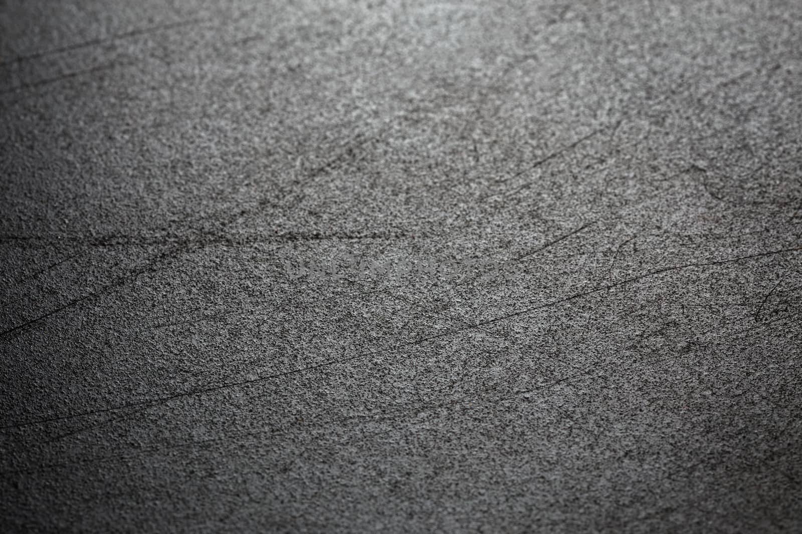 Abstract black scratched suface closeup background with selective focus