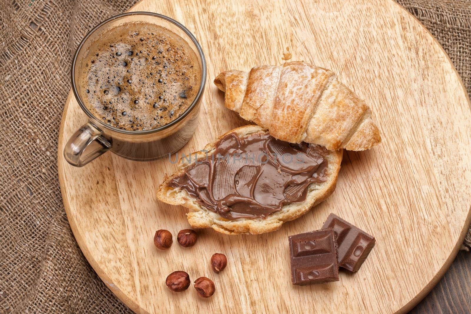 Cup and and pastry with chocolate on a wooden desk