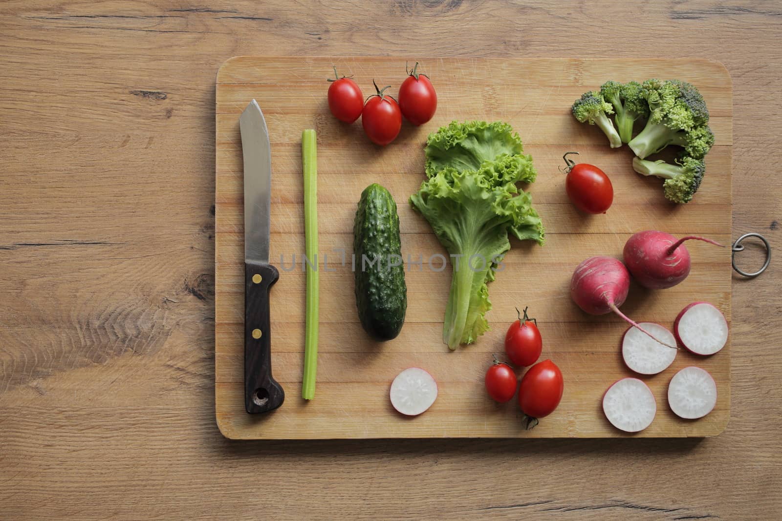 Fresh vegetables on a cutting board on a wooden table by selinsmo