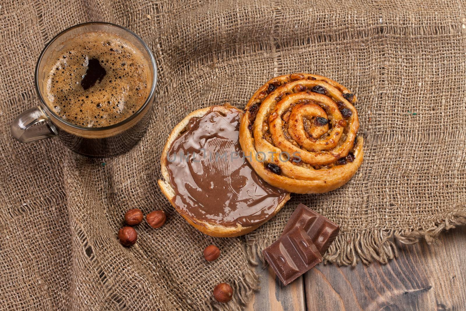 Cup and and pastry with chocolate on a wooden desk