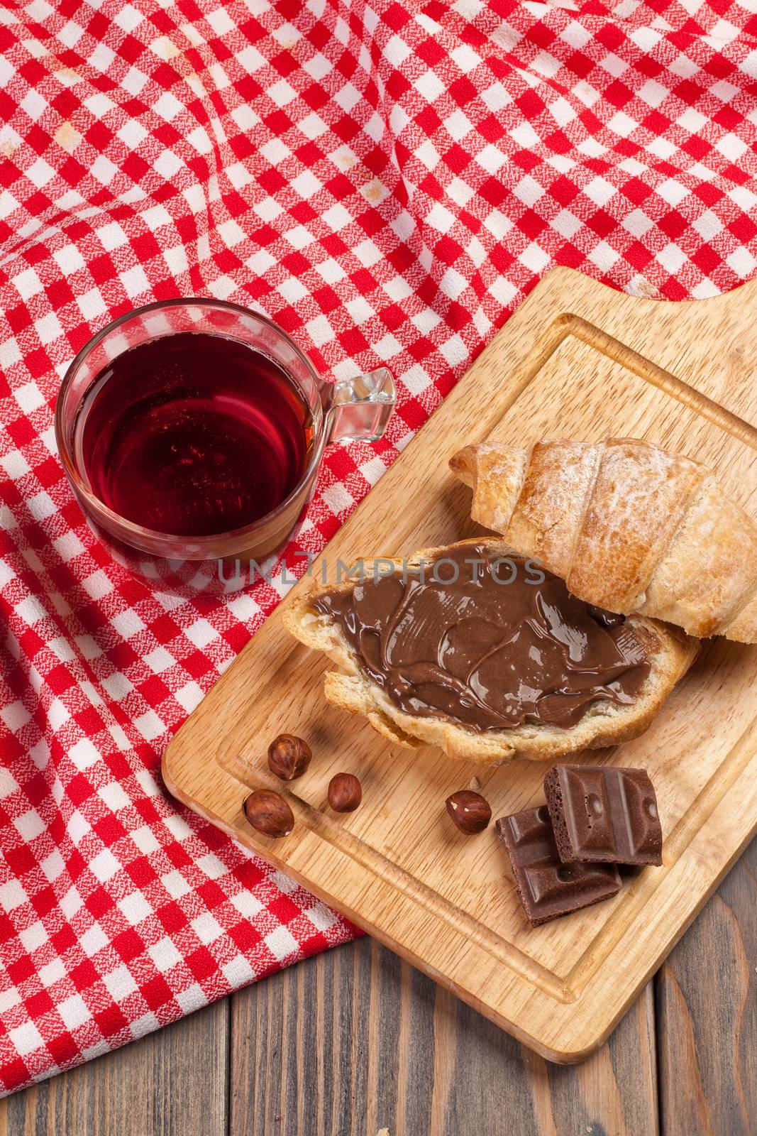 Cup of tea and croissant on a tablecloth