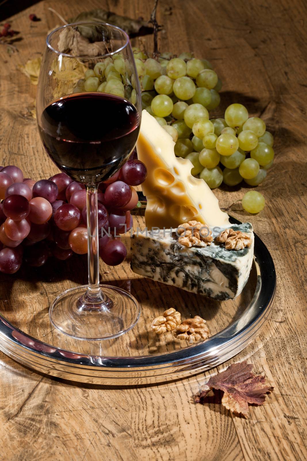 Winem cheese and grapes on a wooden table