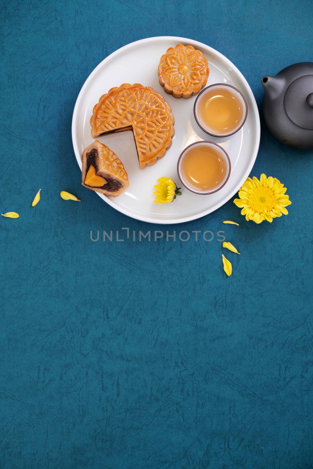 Minimal simplicity layout moon cakes on blue background for Mid-Autumn Festival, creative food design concept, top view, flat lay, copy space.