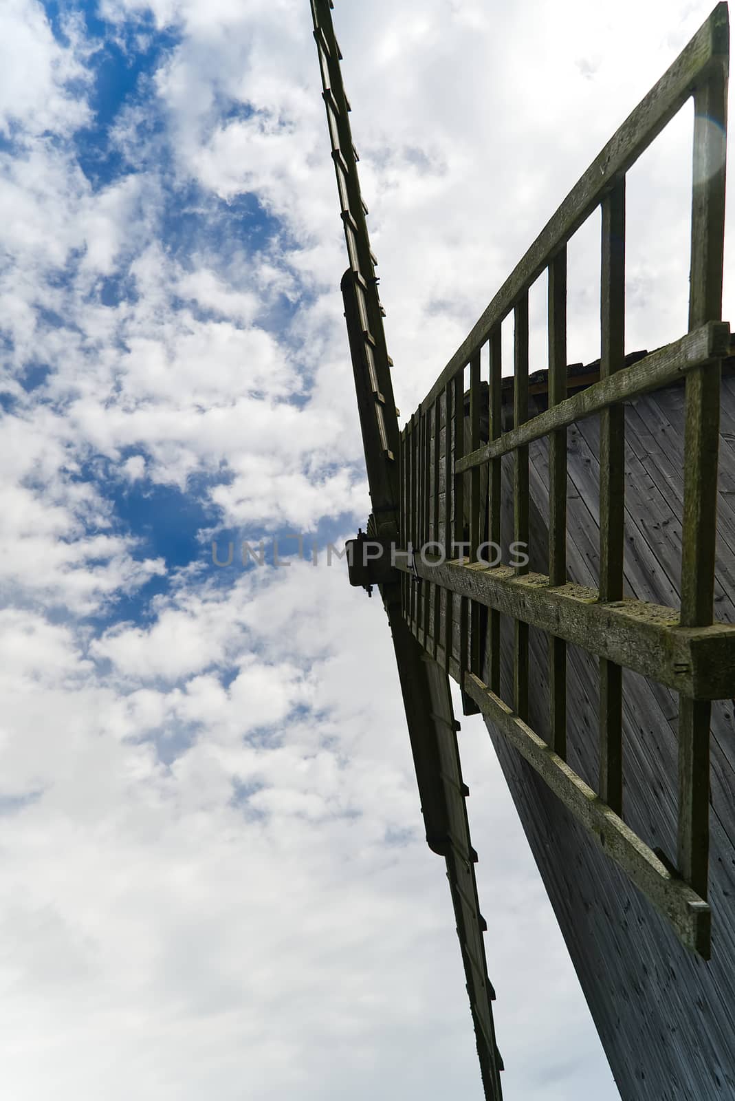 Old vintage wooden windmill in the background of the cloudy sky, selective focus. Saaremaa, Estonia. by PhotoTime