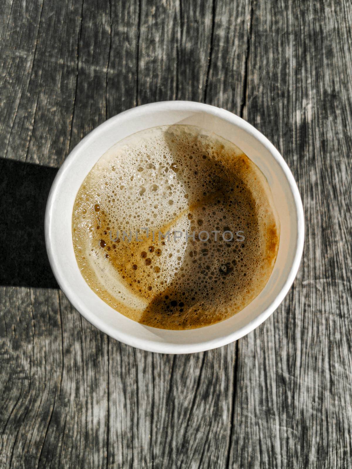 Paper cup with coffee to go on wooden ground texture from above. Leherheide, Bremerhaven.