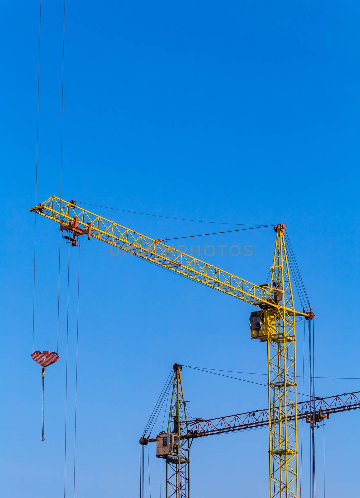 Two cranes with a light blue sky background. by DamantisZ
