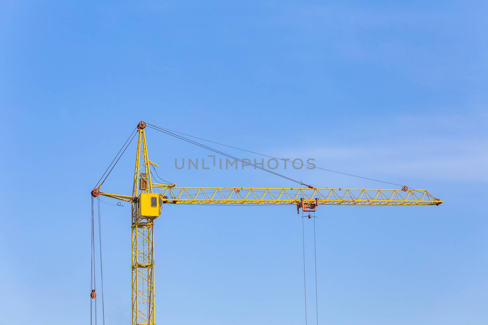 View of a yellow crane. Blue sky background. by DamantisZ