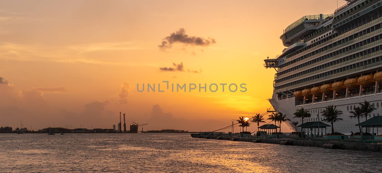 Luxurious cruise liner at sunset docked in Nassau, Bahamas. Golden hour. Beautiful orange-and-yellow sunset. Cruising concept.