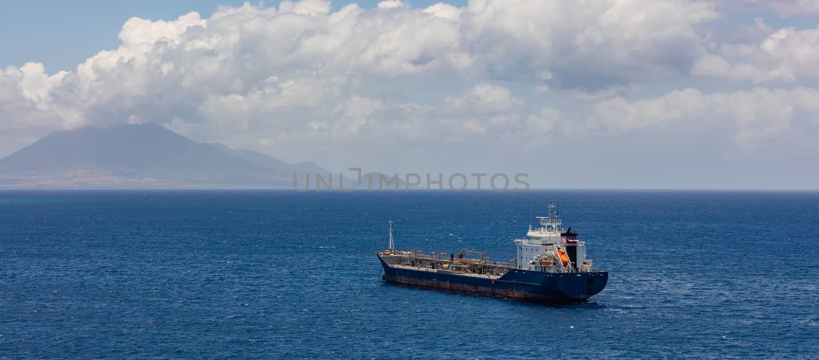 Old oil tanker moving towards St. Eustatius island in the Caribbean. Single life boat in the back of the ship