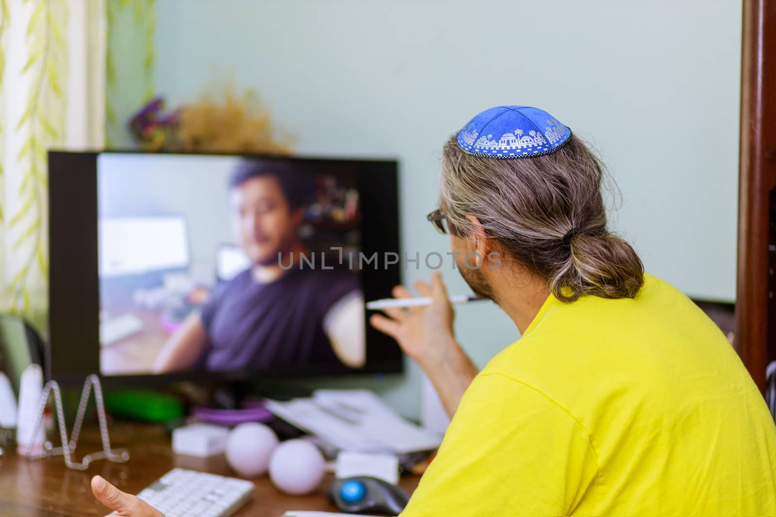 Back view of business jewish man talking about sale report in video conference online work meeting in video call, social isolation with working from home