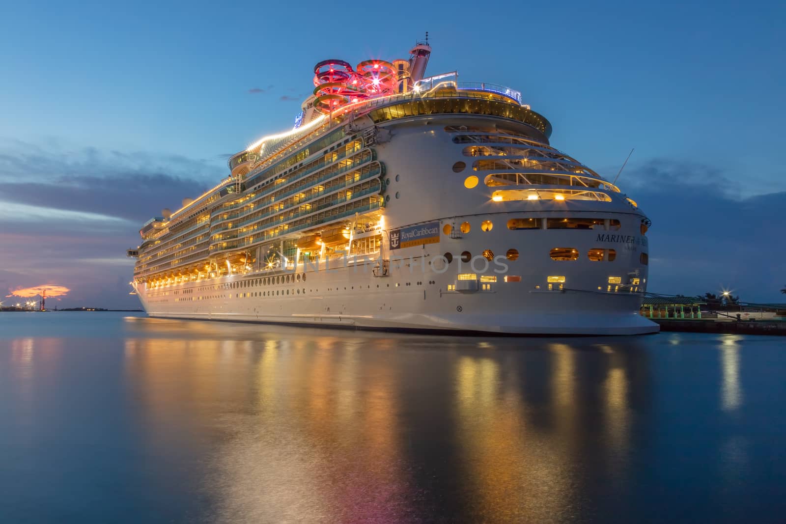 Nassau, Bahamas - August 24, 2019: Beautiful blue hour shot of Royal Caribbean's Mariner of the Seas docked in the port of Nassau. Amazing colors and reflections in the water. Long exposure shot.