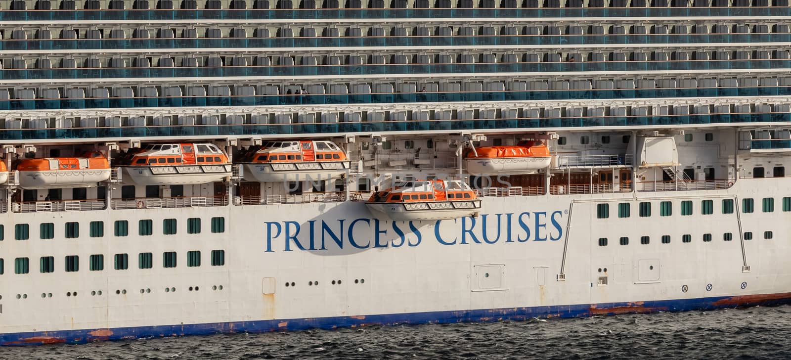 Carlisle Bay, Barbados, West Indies - May 16, 2020: Close view of Emerald Princess cruise ship's port side with the brand name of Princess Cruises on it and life boats above the name.