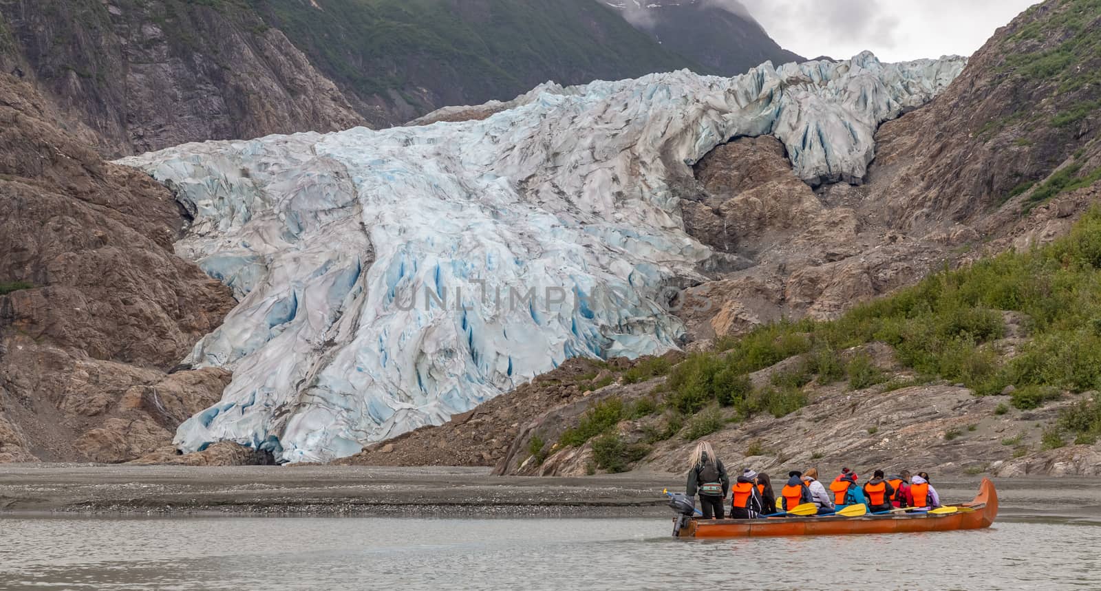 Tourists, a guide drifting in canoe by glacier by DamantisZ