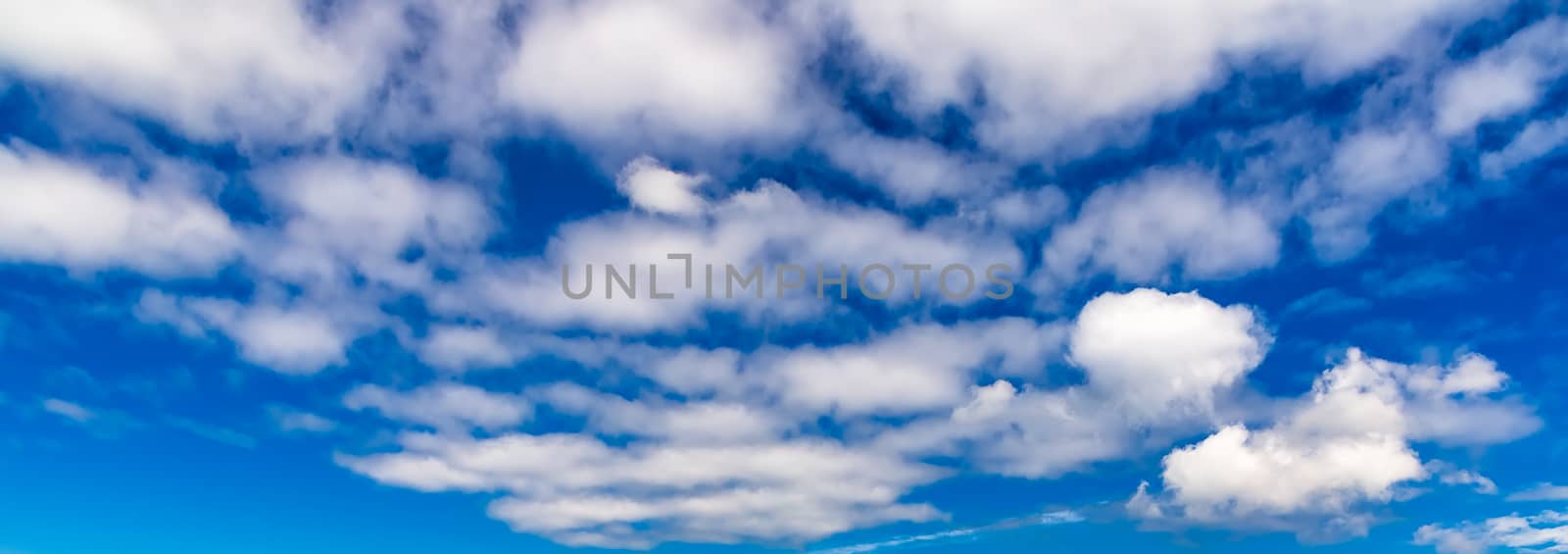 Blue sky background with fluffy white clouds by DamantisZ