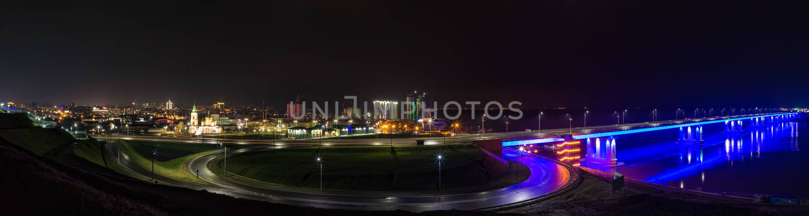 Night panorama of a bridge lit up in the darkness and Barnaul cityscape in Russia