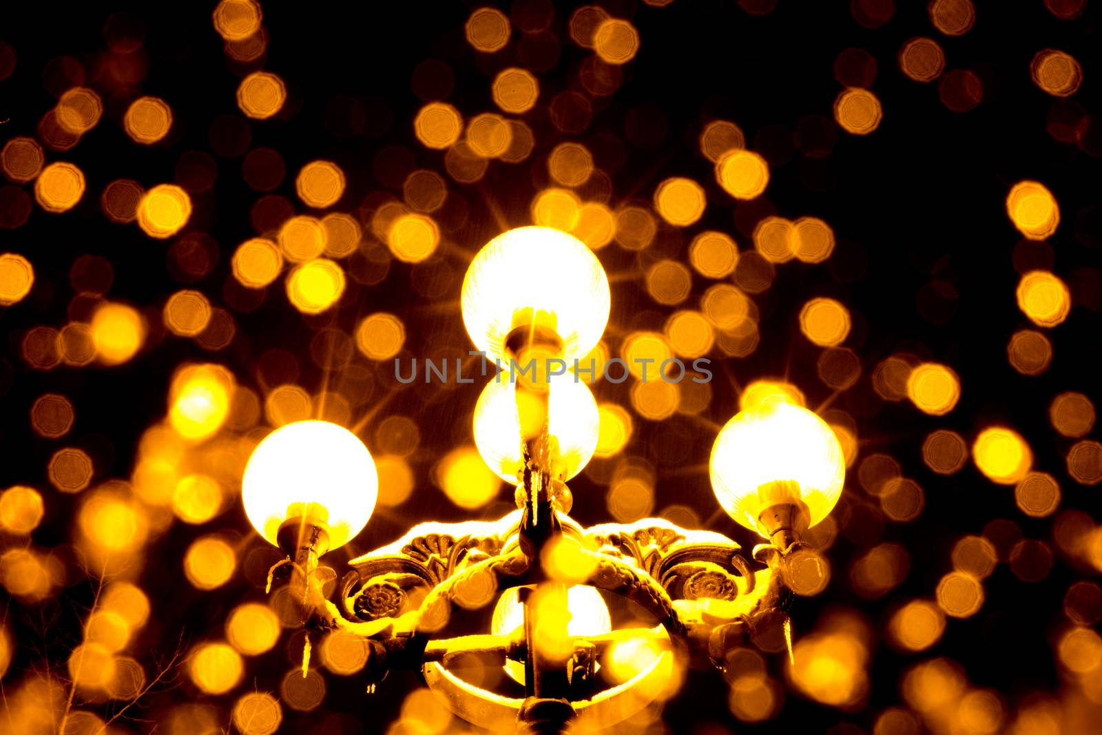 Antique yellow lantern at night with blurred snow flakes falling down