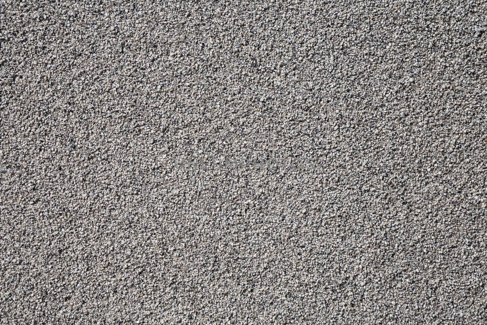 Grey wall made of very small pebble evenly spread around the wall.