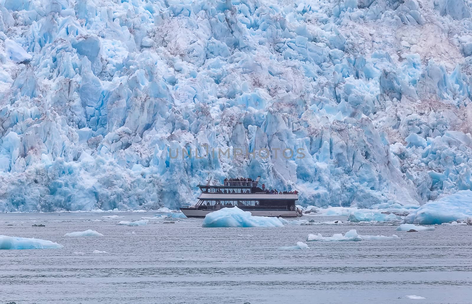 Double-decker boat sailing by a huge glacier by DamantisZ
