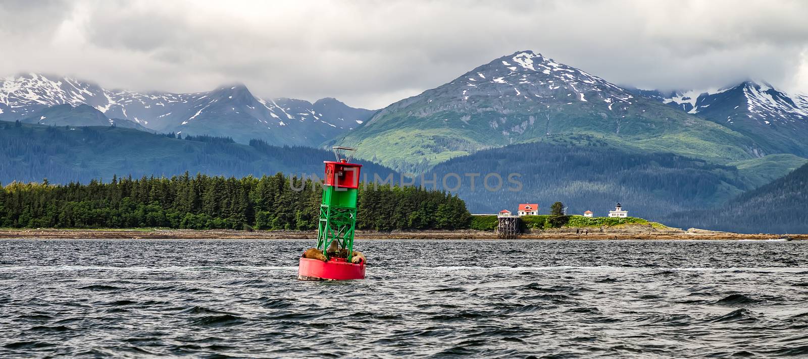 Lighthouse and buoy with mountains in the backdrop by DamantisZ