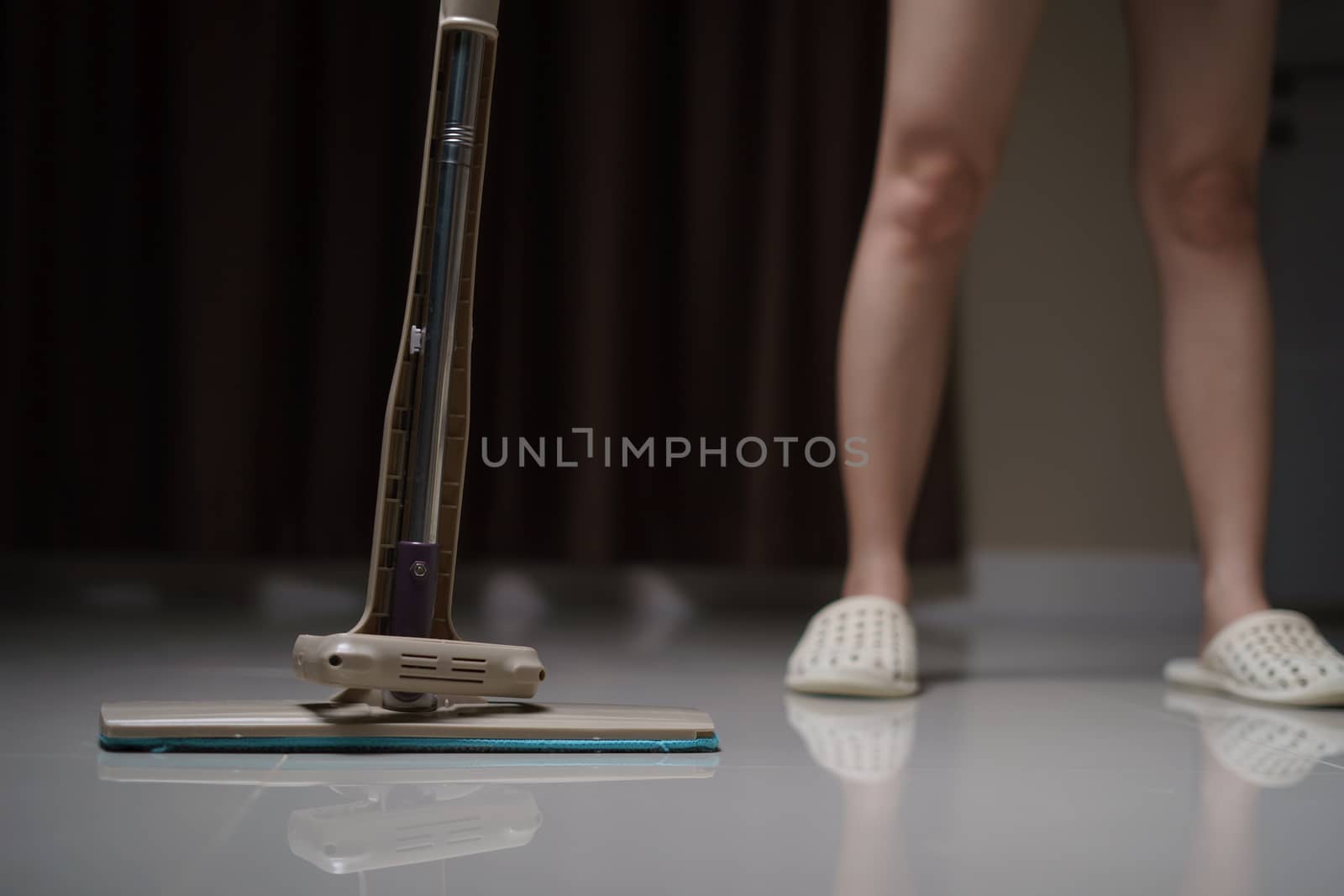 Woman using a flat wet-mop cleaning floor in the house. protect virus covid-19