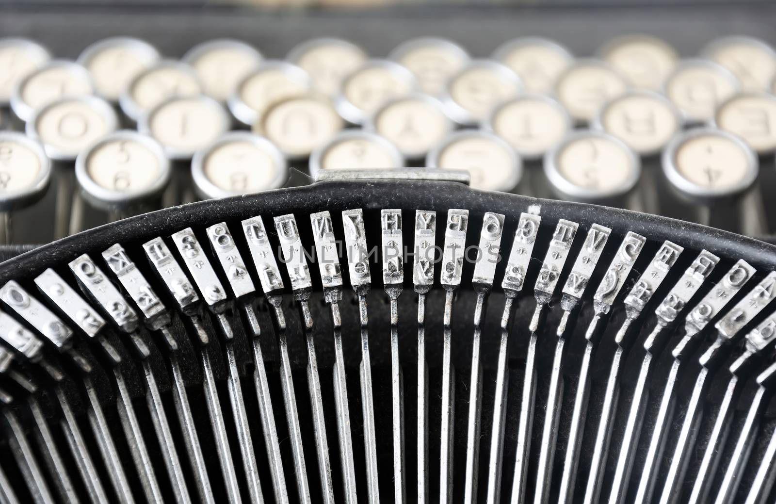 the iron hammers of an old typewriter with the keys blurred in the background. Typing and obsolete technology. Vintage object