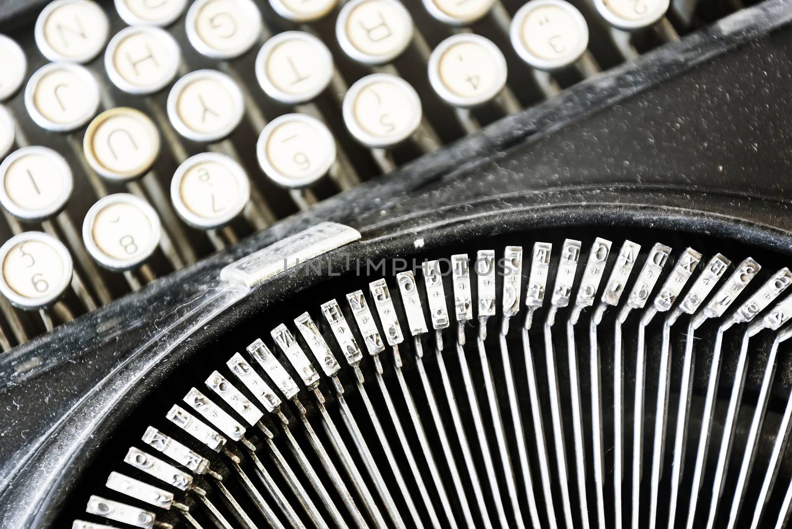 the iron hammers of an old typewriter with the keys blurred in the background. Typing and obsolete technology. Vintage object