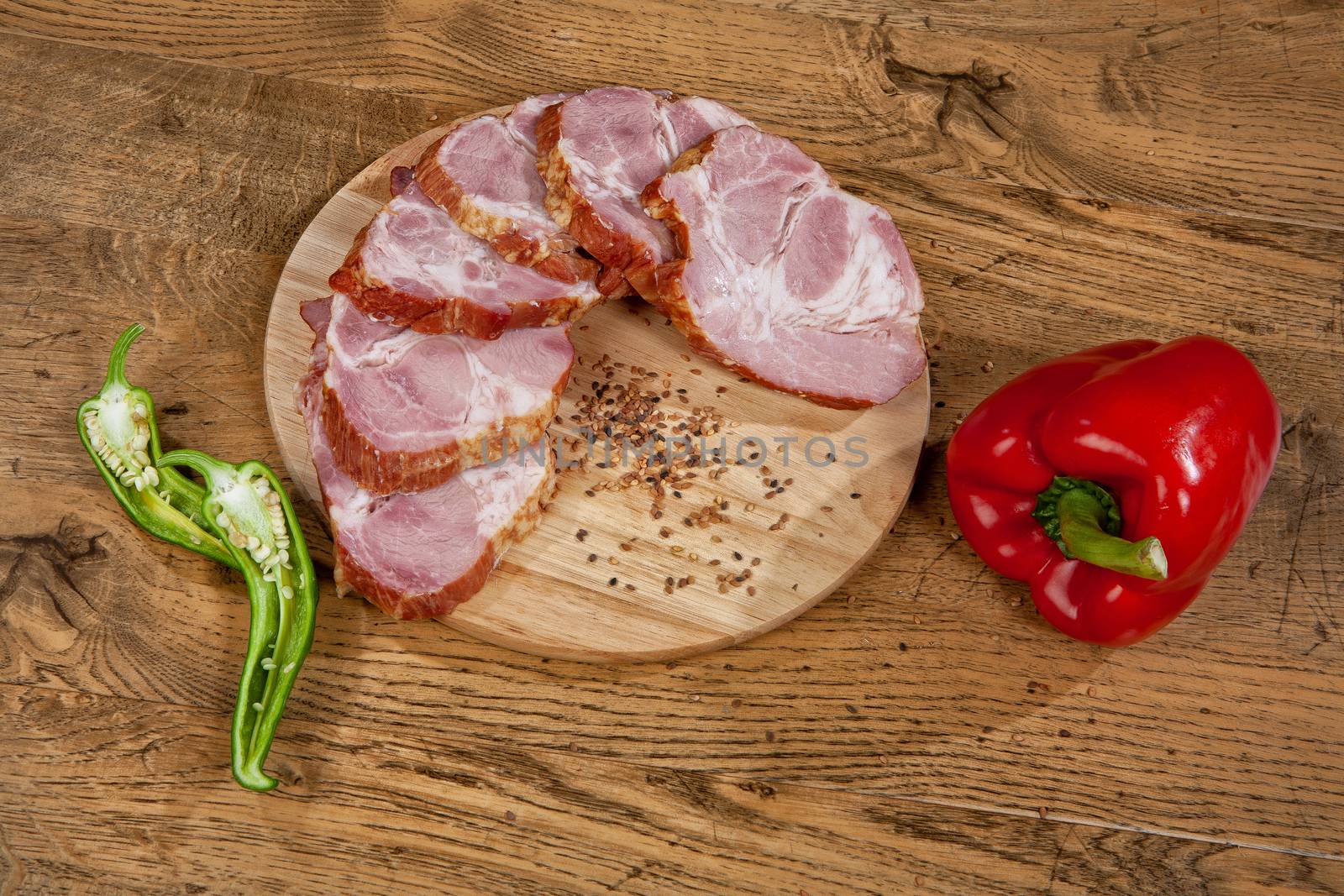 Ham sausage and pepper on a wooden desk