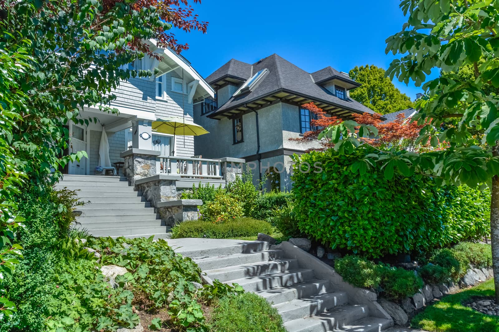 Concrete stairway to main entrance of residential house over the front yard