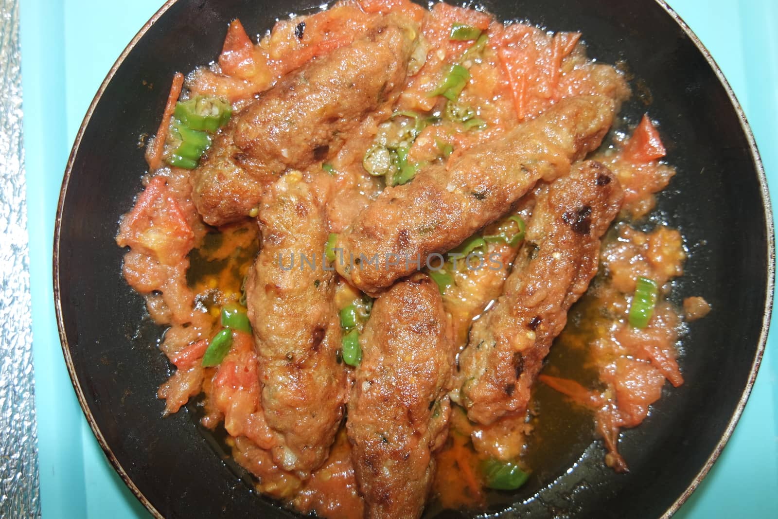 Closeup view of delicious spicy home made fried kebab with green mint leaves and green pepper sprinkled on it