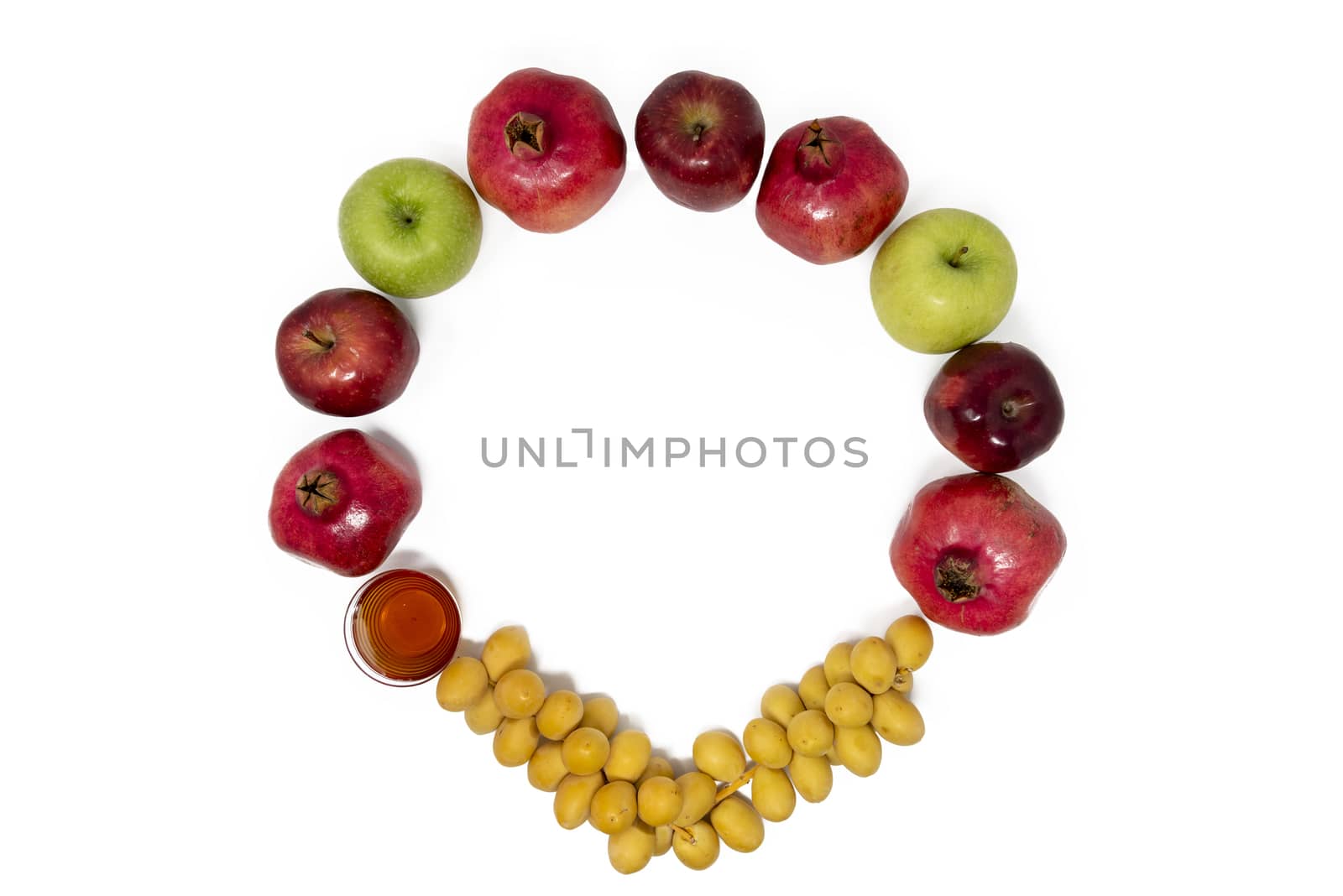 Rosh Hashanah (Jewish New Year) Traditional Symbols, Honey in a glass jar, Pomegranates, Dates, Red And Green Apples. Isolated On A White Background