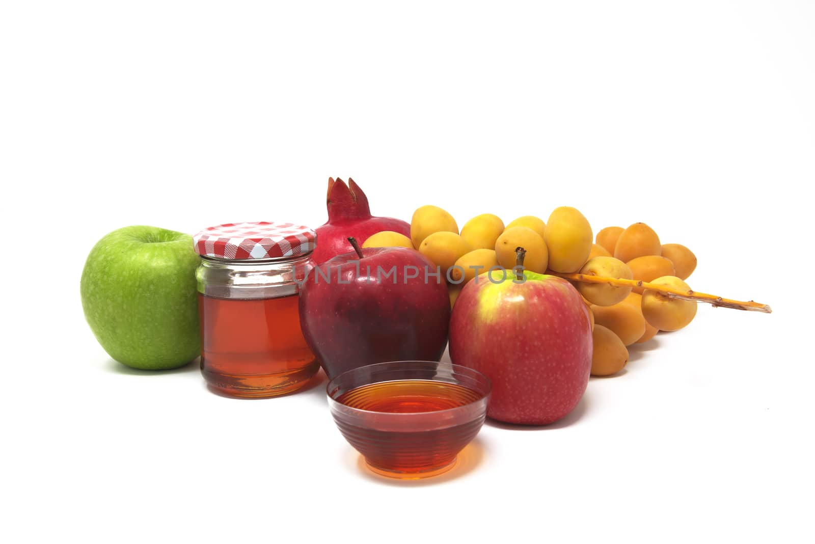 Rosh Hashanah, Jewish New Year, Traditional Symbols, Honey in a glass jar, Pomegranates, Dates, Red And Green Apples. Isolated On A White Background