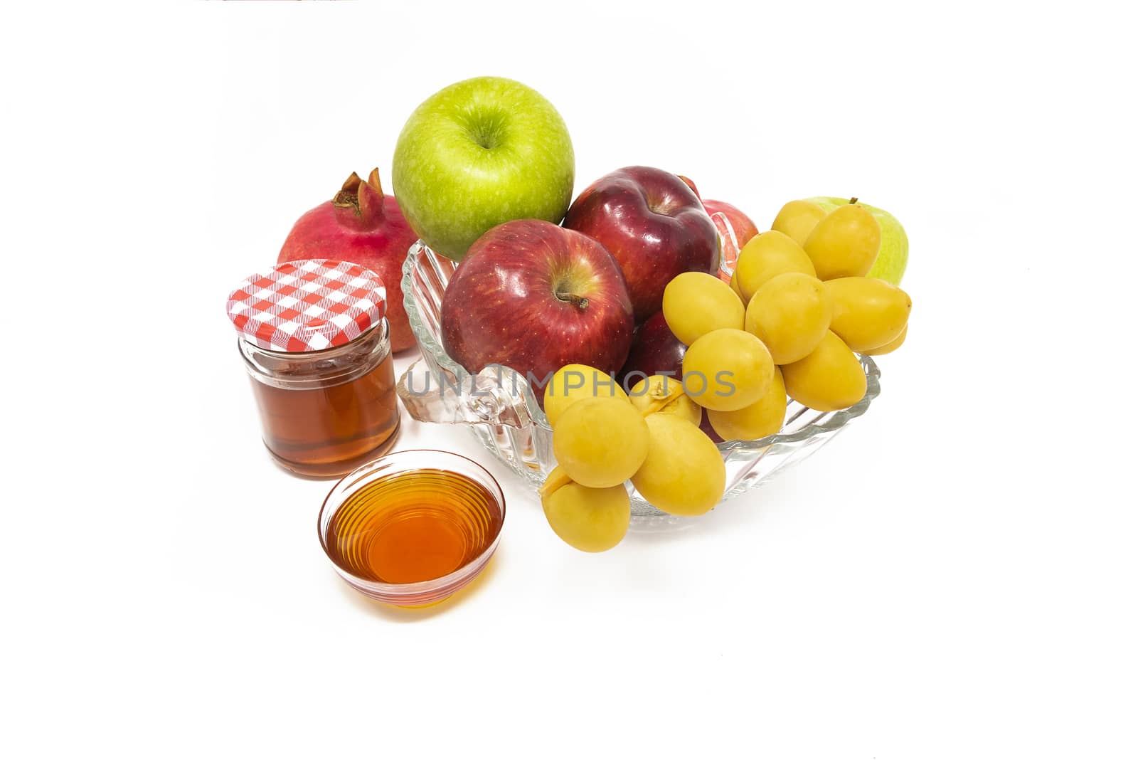 Rosh Hashanah, Jewish New Year, Traditional Symbols, Honey in a glass jar, Pomegranates, Dates, Red And Green Apples. Isolated On A White Background