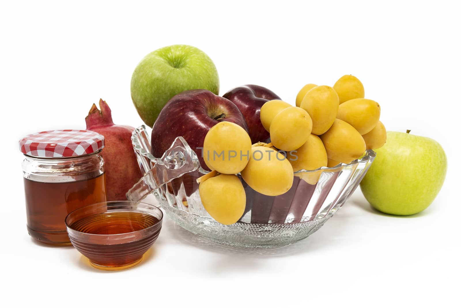 Rosh Hashanah, Jewish New Year, Traditional Symbols, Honey in a glass jar, Pomegranates, Dates, Red And Green Apples. Isolated On A White Background