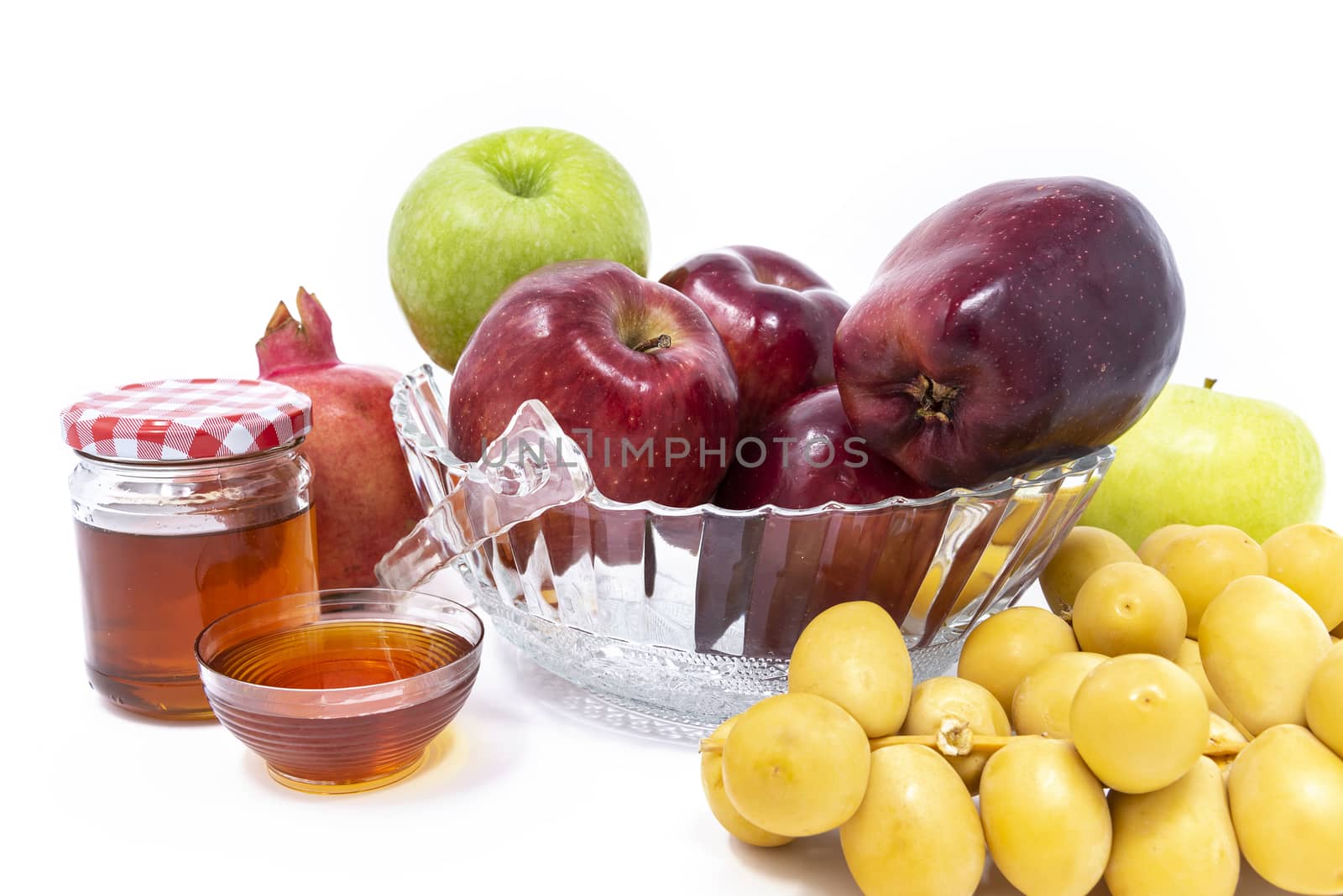 Rosh Hashanah, Jewish New Year, Traditional Symbols, Honey in a glass jar, Pomegranates, Dates, Red And Green Apples. Isolated On A White Background