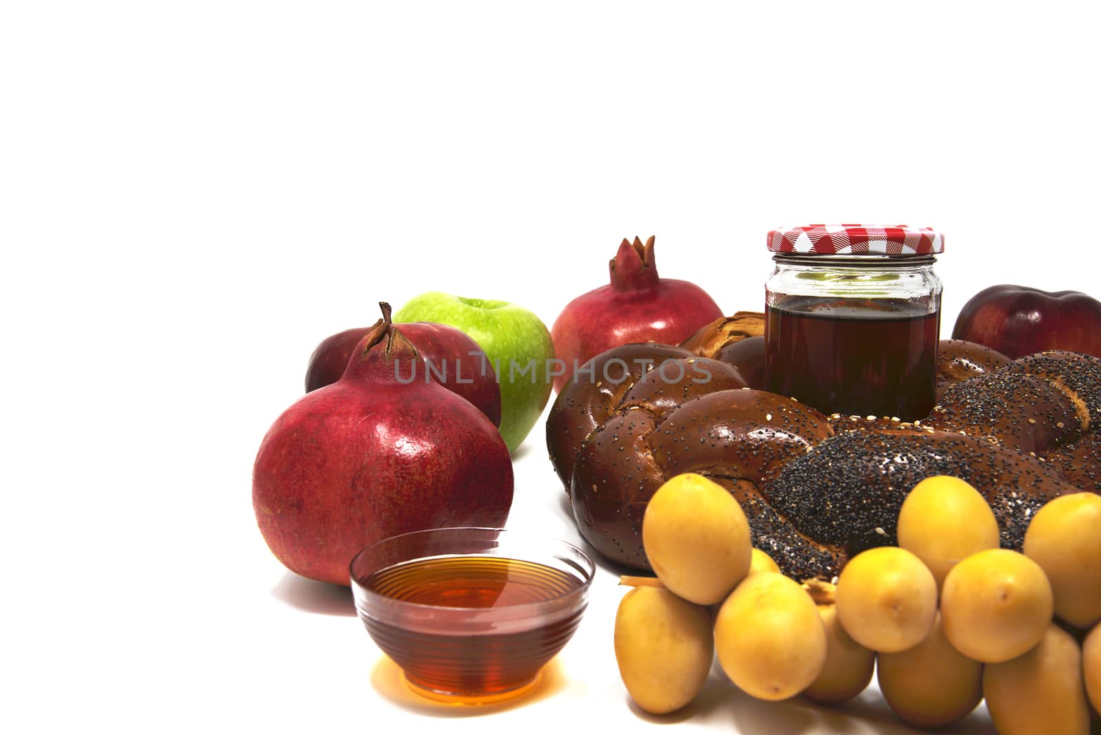 Rosh Hashanah, Jewish New Year, Traditional Symbols, Honey in a glass jar, Pomegranates, Dates, Red And Green Apples, Challah Bread. Isolated On A White Background