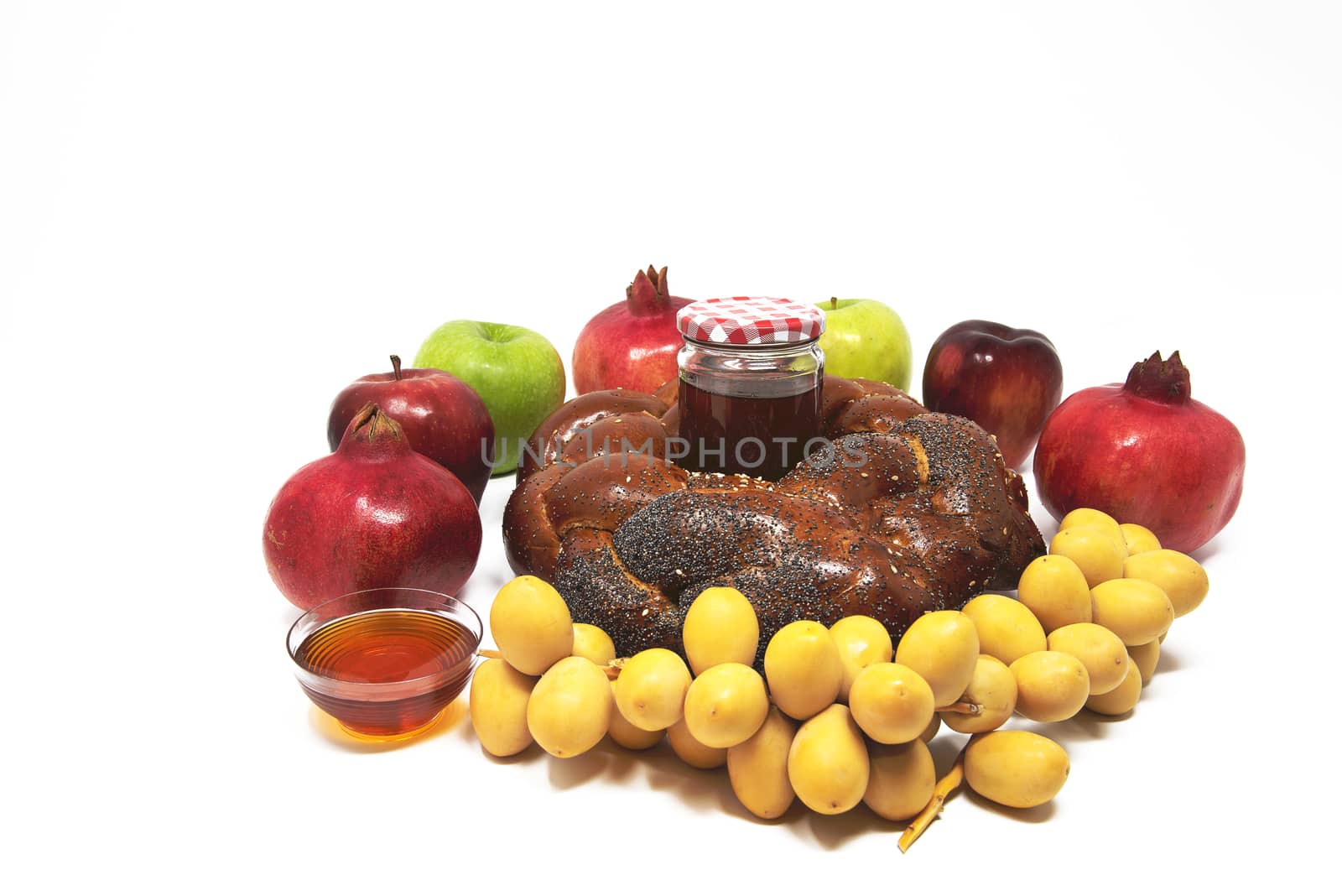 Rosh Hashanah, Jewish New Year, Traditional Symbols, Honey in a glass jar, Pomegranates, Dates, Red And Green Apples, Challah Bread. Isolated On A White Background
