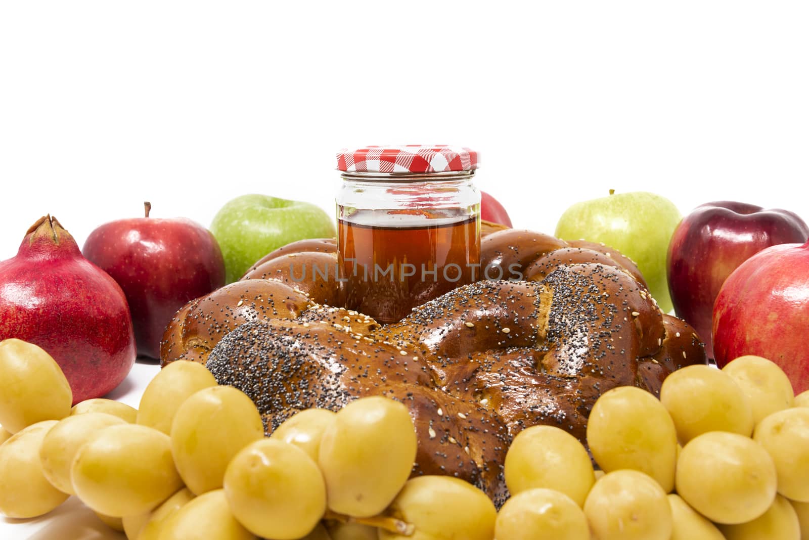 Rosh Hashanah, Jewish New Year, Traditional Symbols, Honey in a glass jar, Pomegranates, Dates, Red And Green Apples, Challah Bread. Isolated On A White Background